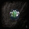 Blauer Saphir von Character Gemstones, 2,19 Karat, mit grünlichem Obsidian-Hintergrund, detailreiche Edelsteinaufnahme.