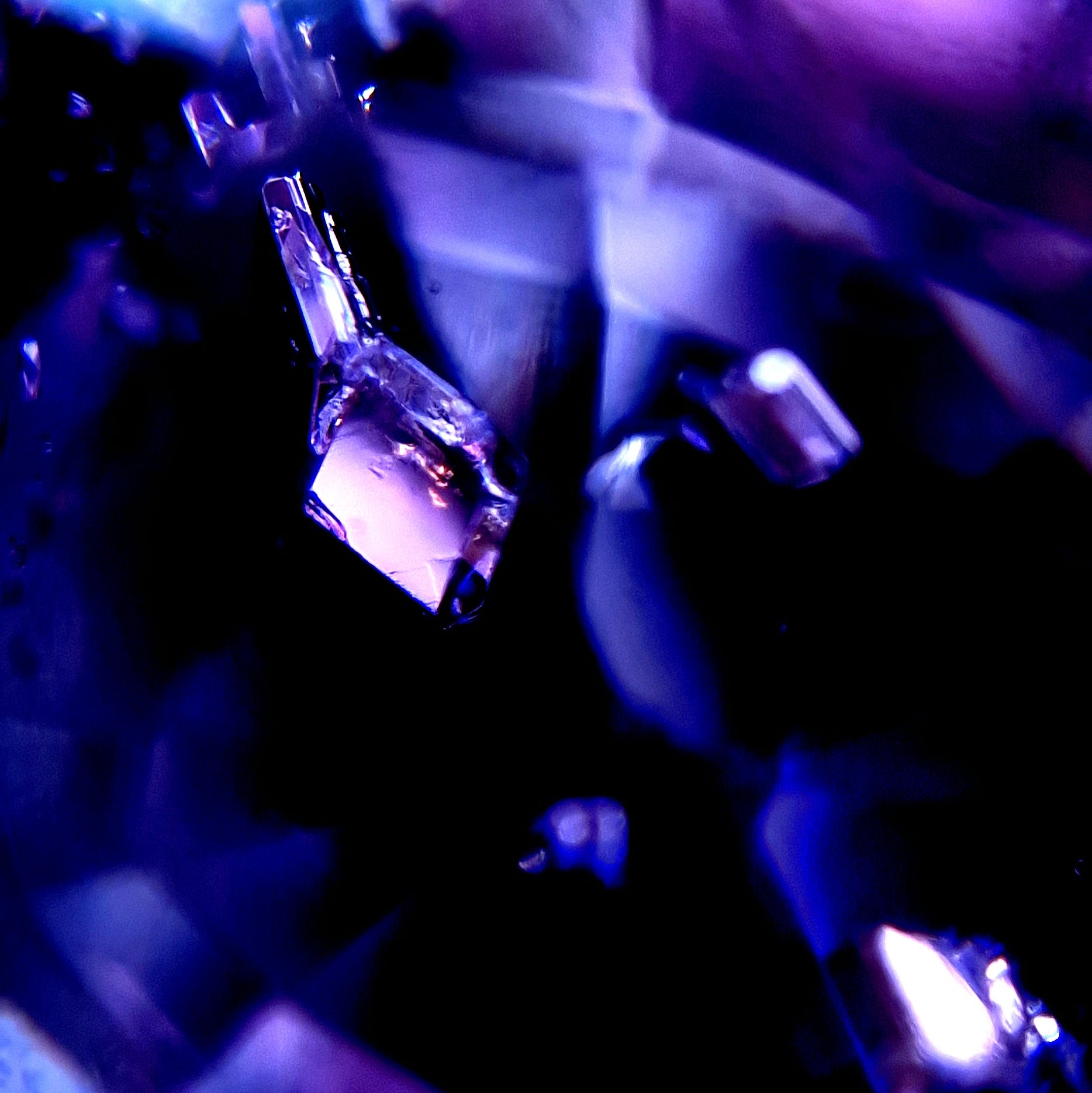 Makrofotografie eines Mahenge Spinells aus Tansania mit blau-violetten Farbtönen und facettiertem Lichtspiel